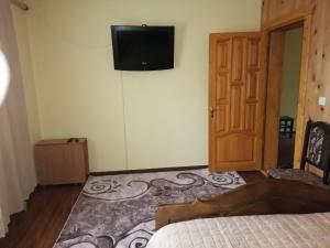 a bedroom with a bed and a television on the wall at Форесок in Vorokhta