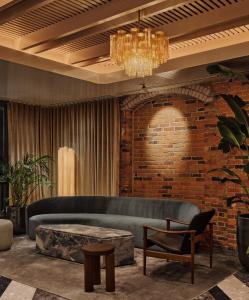 a living room with a couch and a brick wall at Hotel Nelligan in Montreal