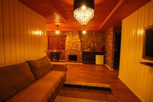 a living room with a couch and a chandelier at Café e Cabanas Lenha no Fogo in Urubici