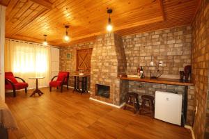 a living room with a fireplace and red chairs at Café e Cabanas Lenha no Fogo in Urubici