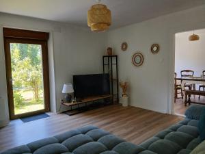 a living room with a couch and a television at La maison bleue-Urbès in Urbès