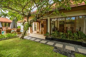 a house with a garden and a patio at Villa Seriska Dua Sanur with Private Pool in Sanur
