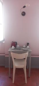 a table with a white chair and a table with a bag on it at CA' 'D Ricardo in Alba