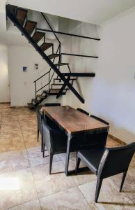 a table and chairs in a room with a staircase at Depto Civora 1 in Villa Regina +2 photos