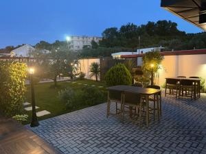 a patio with tables and chairs at night at Marini Casa in Ulcinj