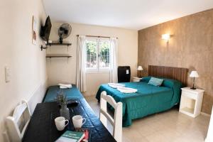a hotel room with two beds and a table and a table sidx sidx at Kumen Apart de Playa in San Bernardo