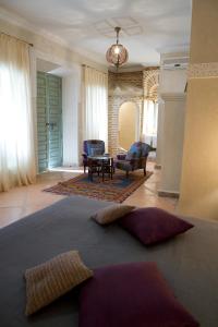 a living room with a large rug on the floor at Riad Les Hibiscus in Marrakesh