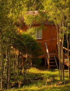 a cabin in the woods with a porch and stairs to it at Cabana Recanto dos Aparados in Cambará
