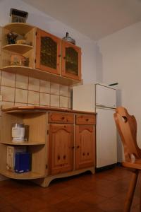 a kitchen with wooden cabinets and a refrigerator at Appartamento Villa Rendena in Porte di Rendena