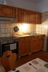 a kitchen with wooden cabinets and a sink and a stove at Appartamento Villa Rendena in Porte di Rendena +2 photos