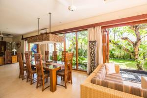 a living room with a couch and a table and chairs at Villa Seriska Dua Sanur with Private Pool in Sanur