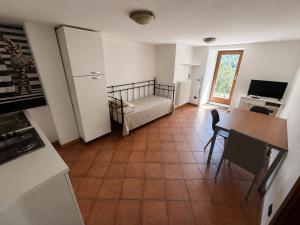 a room with a kitchen with a table and a couch at Maison Jaune 26 in Aosta