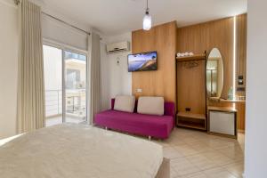 a living room with a purple couch and a mirror at Hotel Bella Vista in Orikum