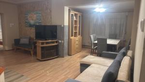 a living room with a couch and a television at Kerka Szállás in Kerkabarabás