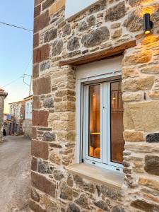a window in a stone building with a wooden ledge at Κουρείον Kourion in Agios Vlasios