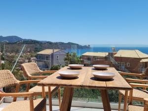 a wooden table with bowls on top of a balcony at Miranda Haus in Arillas