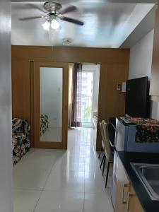 a kitchen with a ceiling fan and a living room at Shell Residences MOA Elegant Place in Manila