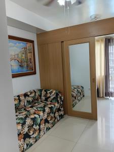 a living room with a couch and a mirror at Shell Residences MOA Elegant Place in Manila +10 photos