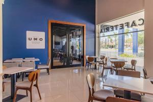 a restaurant with tables and chairs and a blue wall at Hotel Nuve Gomez Palacio in Gómez Palacio