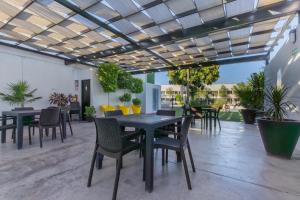 a patio with tables and chairs and potted plants at Hotel Nuve Gomez Palacio in Gómez Palacio