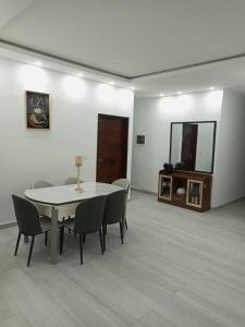 a dining room with a table and chairs and a mirror at CarteSurTable - Votre havre de paix aux portes de la ville - Villa haut standing in Yamoussoukro