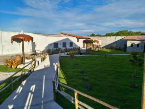 a building with a green yard with umbrellas at Pousada Flor De Prado in Prado