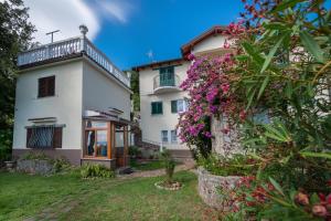 a white house with flowers in front of it at House H-ELIOS in Lovran
