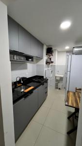 a kitchen with a sink and a refrigerator at Apartamento completo, moderno e bem localizado in Parnamirim