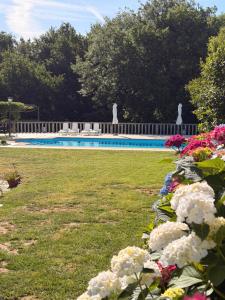 a yard with flowers and a swimming pool at Hotel rústico Aldea Figueiredo in Ourense