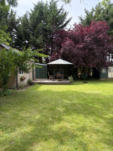 a backyard with a table and a gazebo at River Cabin Retreat in Shepperton
