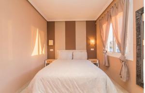 a bedroom with a white bed and a window at Bungalow en la Playa con Terraza Soleada, Jacuzzi, Solarium, Piscina comunitaria in Gran Alacant +62 photos