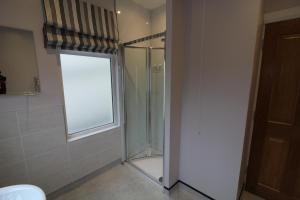a bathroom with a glass shower with a window at Townlets Townhouse in Belfast