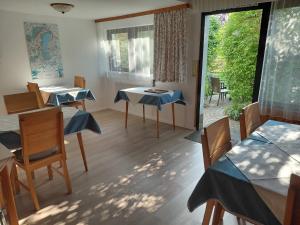 a room with tables and chairs and a large window at Gästehaus Gabriel in Illmitz +23 photos