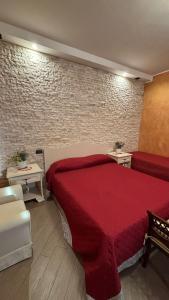 a bedroom with a red bed and a brick wall at B&b MAURO in Gioia Sannitica