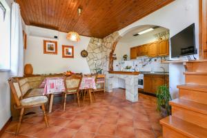 a kitchen and dining room with a table and chairs at House H-ELIOS in Lovran