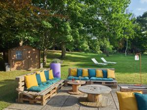 a patio with a couch and a table and chairs at Novotel Massy Palaiseau in Palaiseau