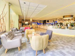 a waiting room with chairs and a table at Novotel Paris Nord Expo Aulnay in Aulnay-sous-Bois