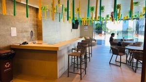 a restaurant with a bar with chairs and tables at Beach Class Internacional Transamerica in Recife