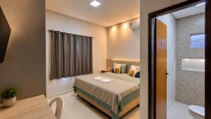 a small bedroom with a bed and a bathroom at Pousada Loft Marabá in Marabá