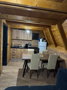 a kitchen with a wooden table and chairs at Vila Kalkan in Šipovo