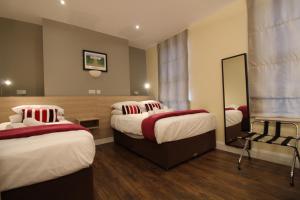 a hotel room with two beds and a mirror at Townlets Townhouse in Belfast