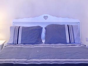a bed with purple sheets and purple pillows at Luciano Valletta Studio - Self Catering in Valletta