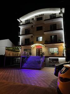 a building with purple stairs in front of it at night at Vila Zara in Mamaia Sat/Năvodari