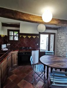 a kitchen with a table and chairs in a room at Maison de village, Verdon in Trigance