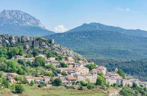 a village on a hill with mountains in the background at Maison de village, Verdon in Trigance