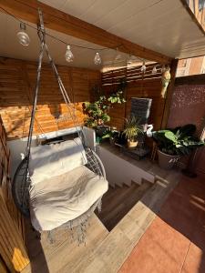 a swinging bed in a room with potted plants at Bungalow en la Playa con Terraza Soleada, Jacuzzi, Solarium, Piscina comunitaria in Gran Alacant