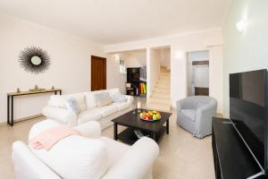 a living room with a white couch and a tv at Villa Situla in Barbati