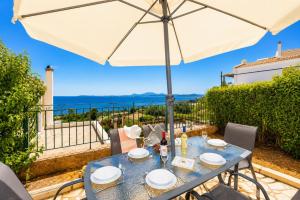 a table with an umbrella on a patio at Villa Situla in Barbati