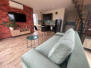 a living room with a couch and a brick wall at Perła prosto z Borów in Cekcyn