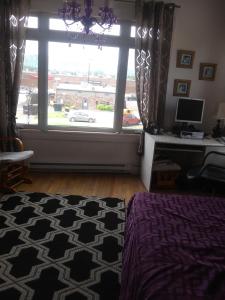 a bedroom with a large window with a car outside at Appartement centre ville de Campbellton NB in Campbellton